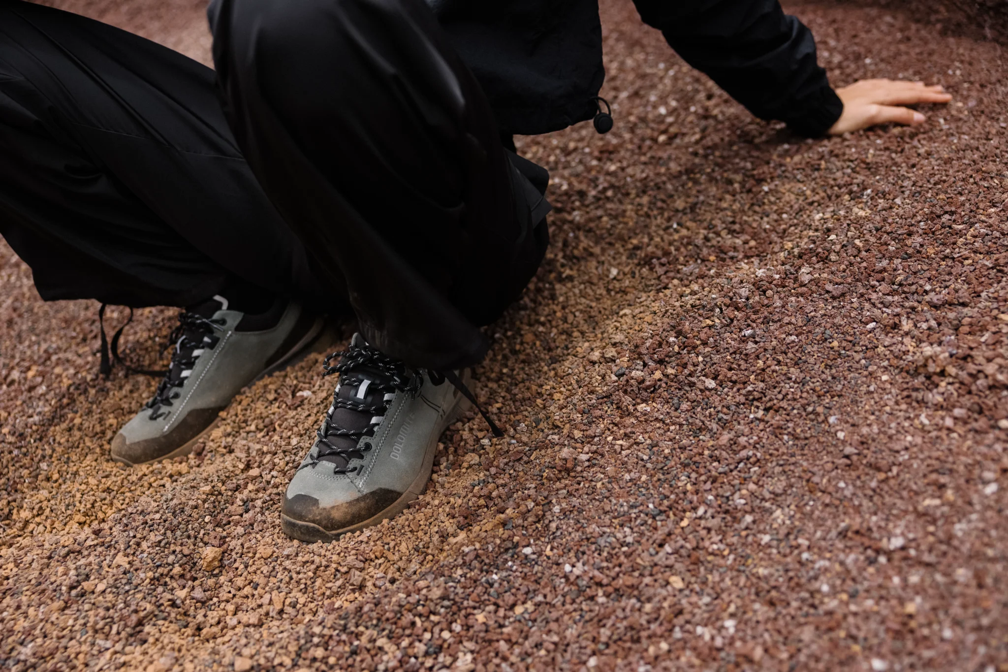 Dolomite-wandelschoenen op een pad van rood grind