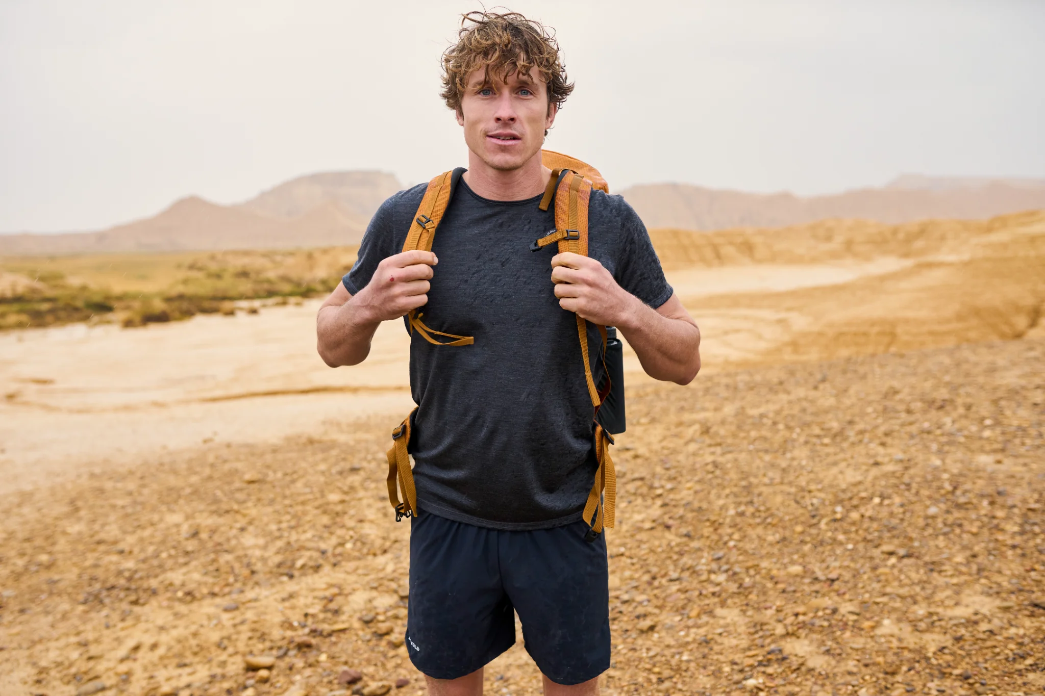 Wandelaar in een Devold-shirt met rugzak in open landschap