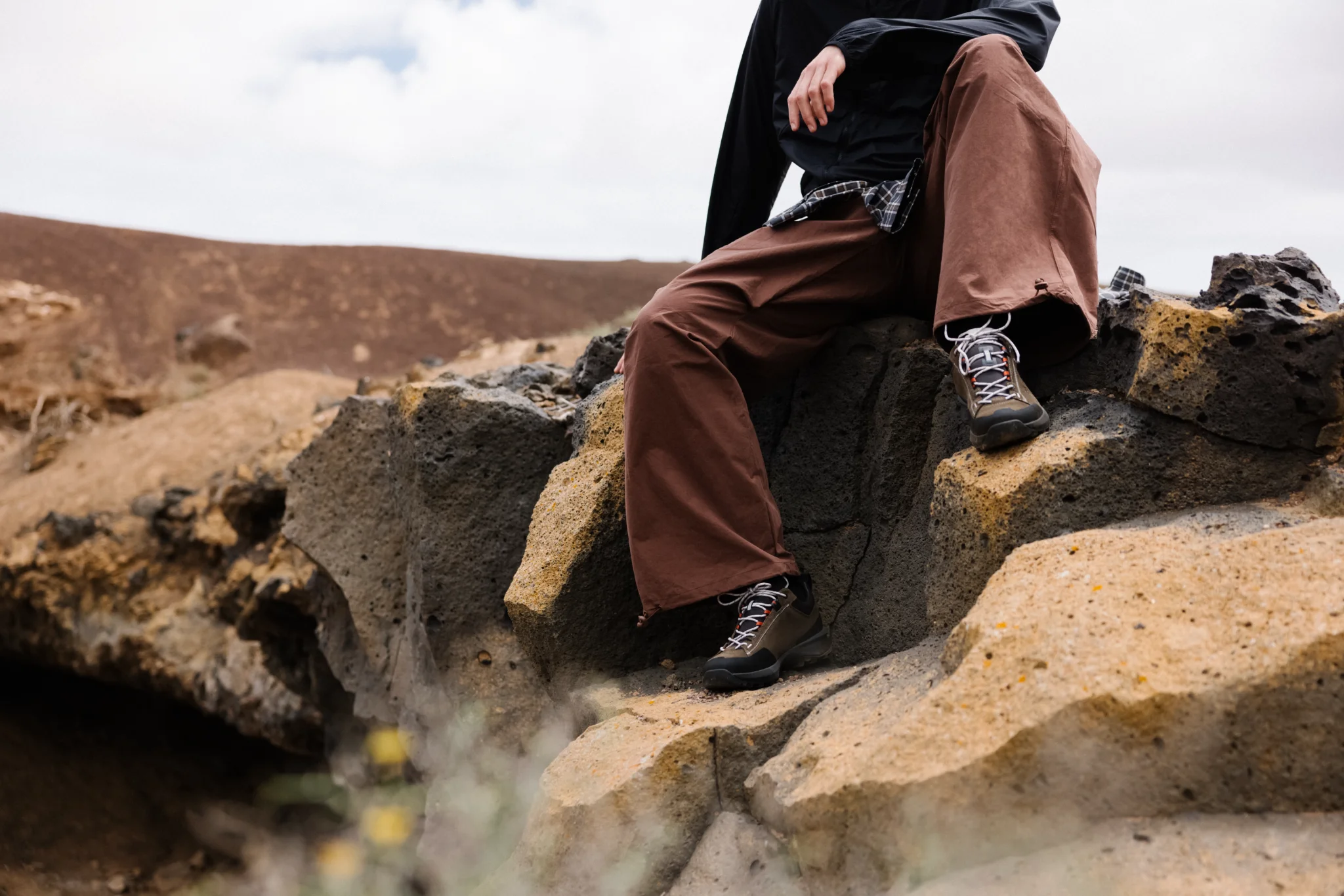 Outdoorschoenen tijdens een pauze op een vulkanische rots