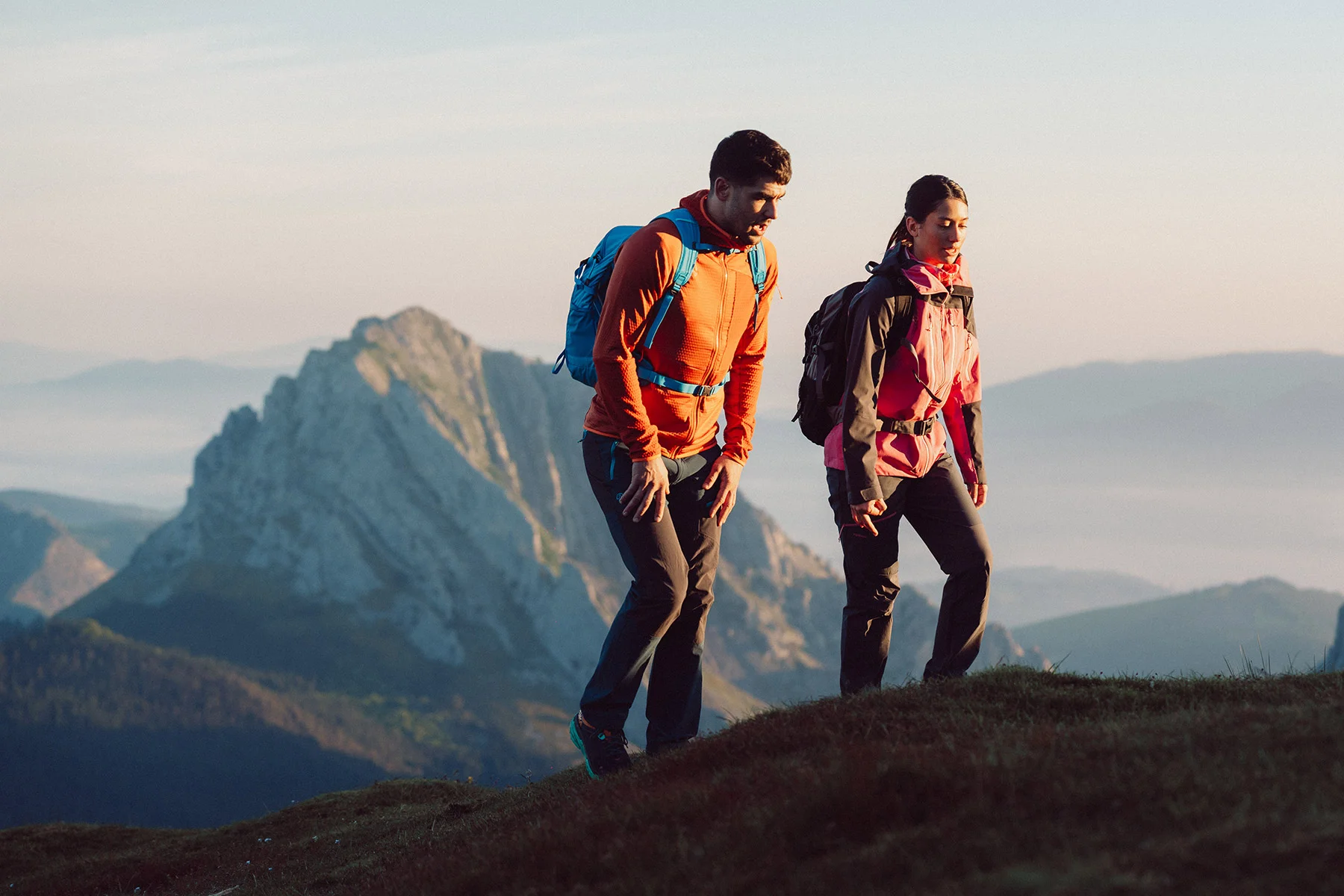 Hiker with a backpack on a Basque mountain path at sunrise
