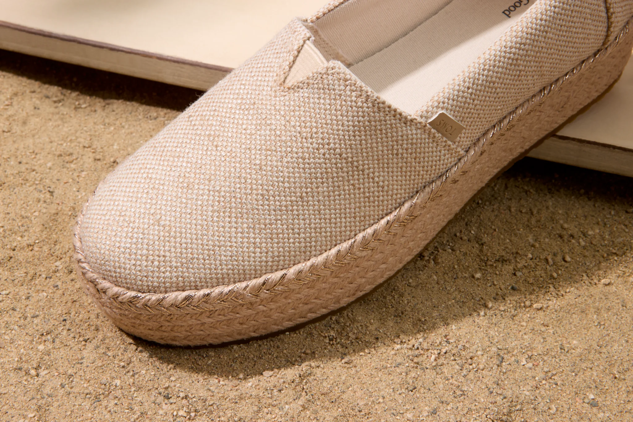 Beige TOMS-espadrille op zand