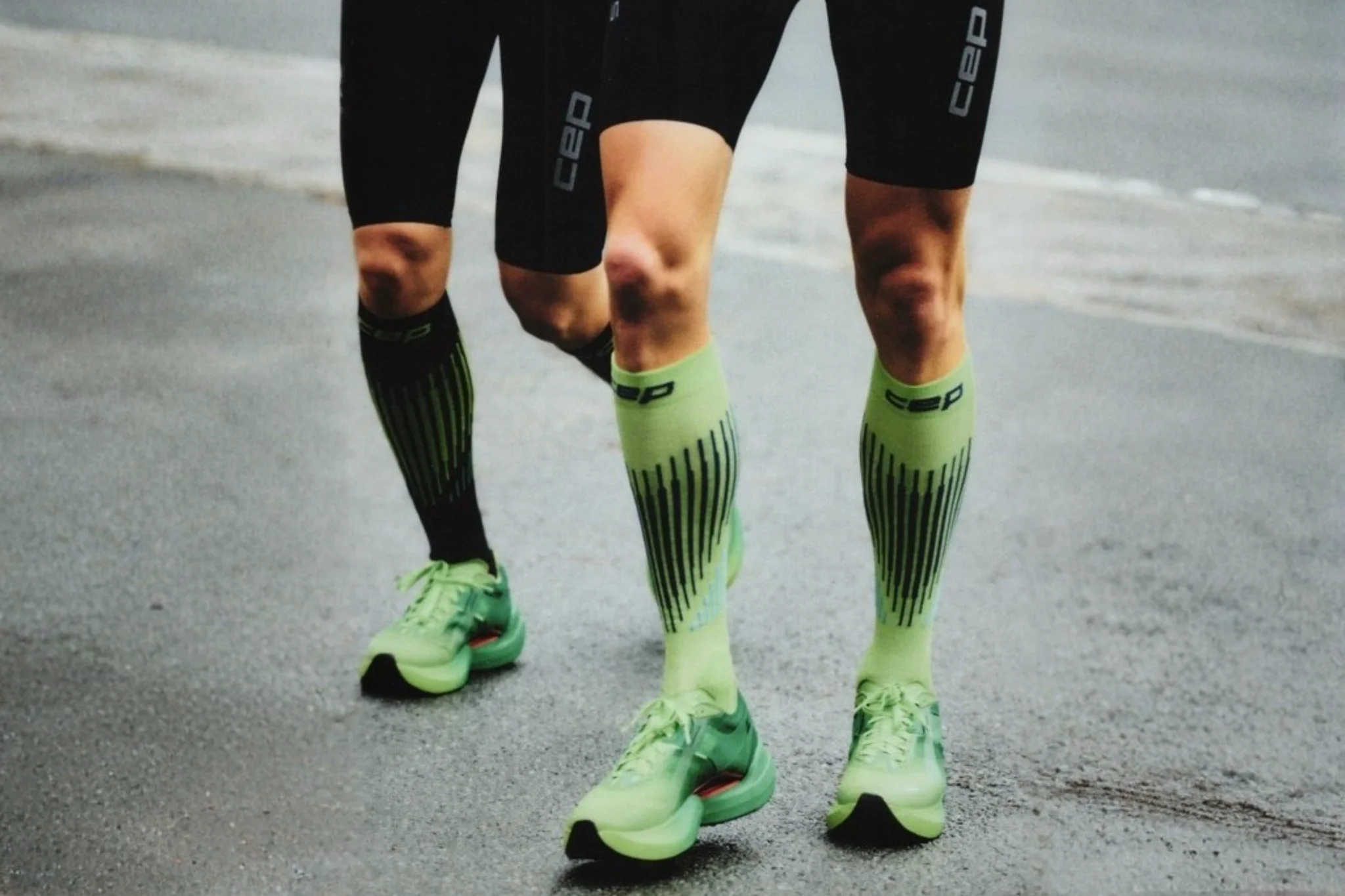 Twee sporters met groene compressiekousen na het hardlopen