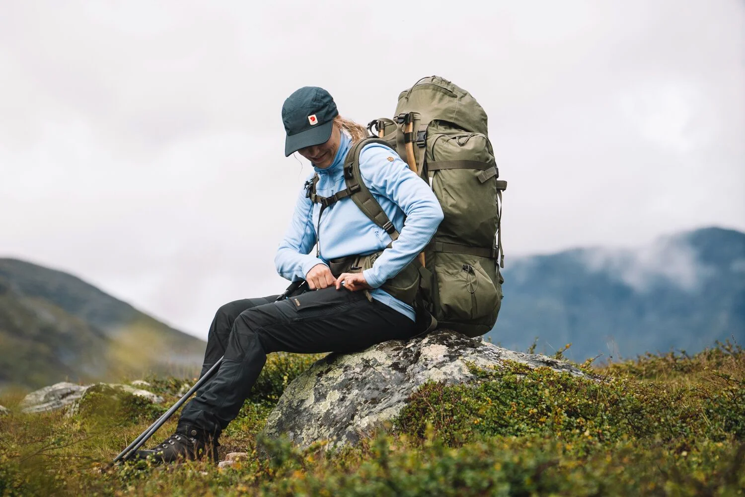 Wandelaar rust met een grote trekkingrugzak in de bergen